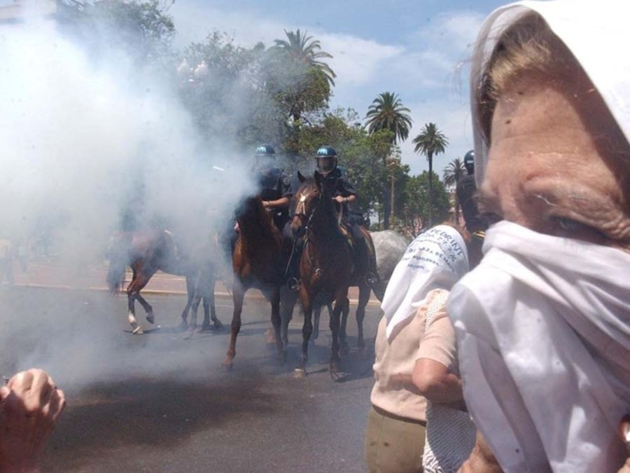 Madre tapandose la nariz con un pañuelo por el gas lacrimogeno